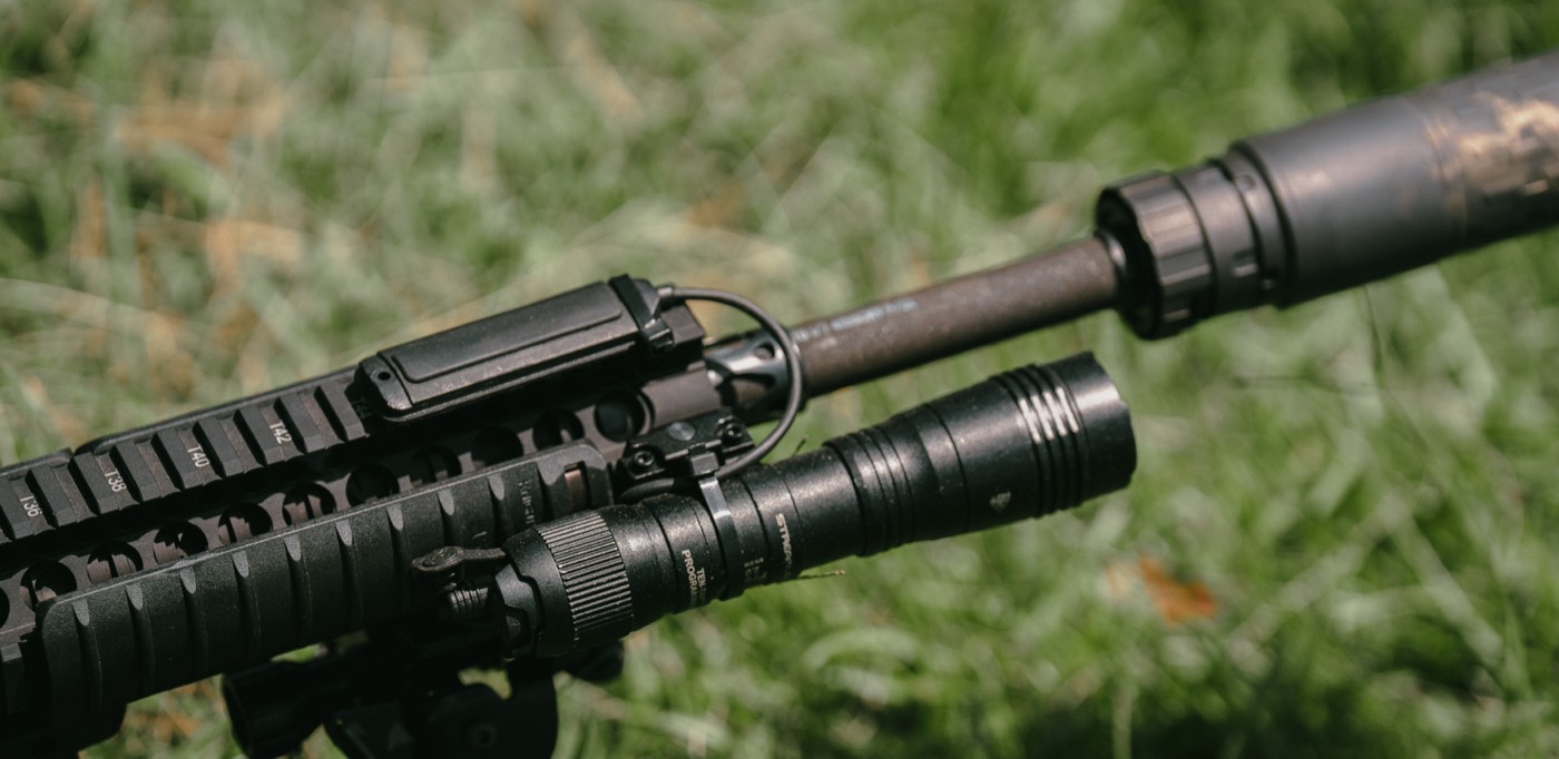 Close-up of a suppressor and gas block on a tuned AR-15