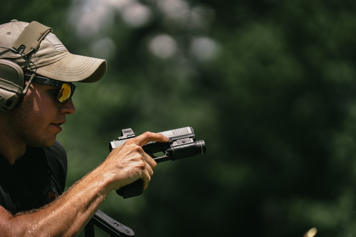 Optic-equipped pistol being fired on the range