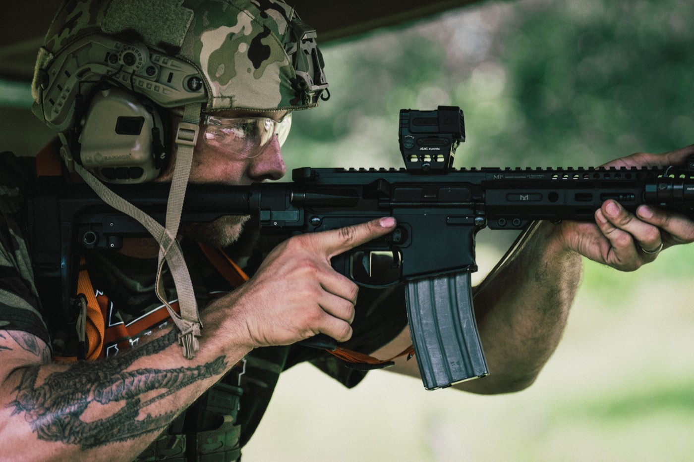 Close-up of a shooter running an AR-15 with a red dot