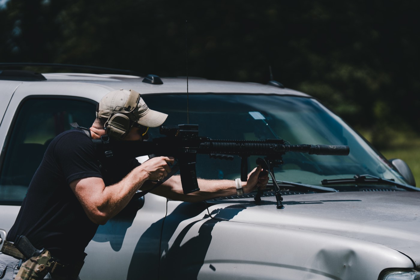Shooter firing an AR-15 braced over a truck hood