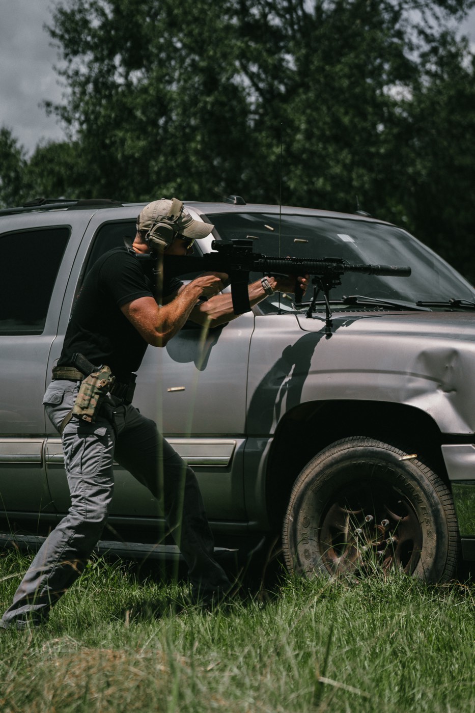 Shooter working alongside a vehicle with an AR-15