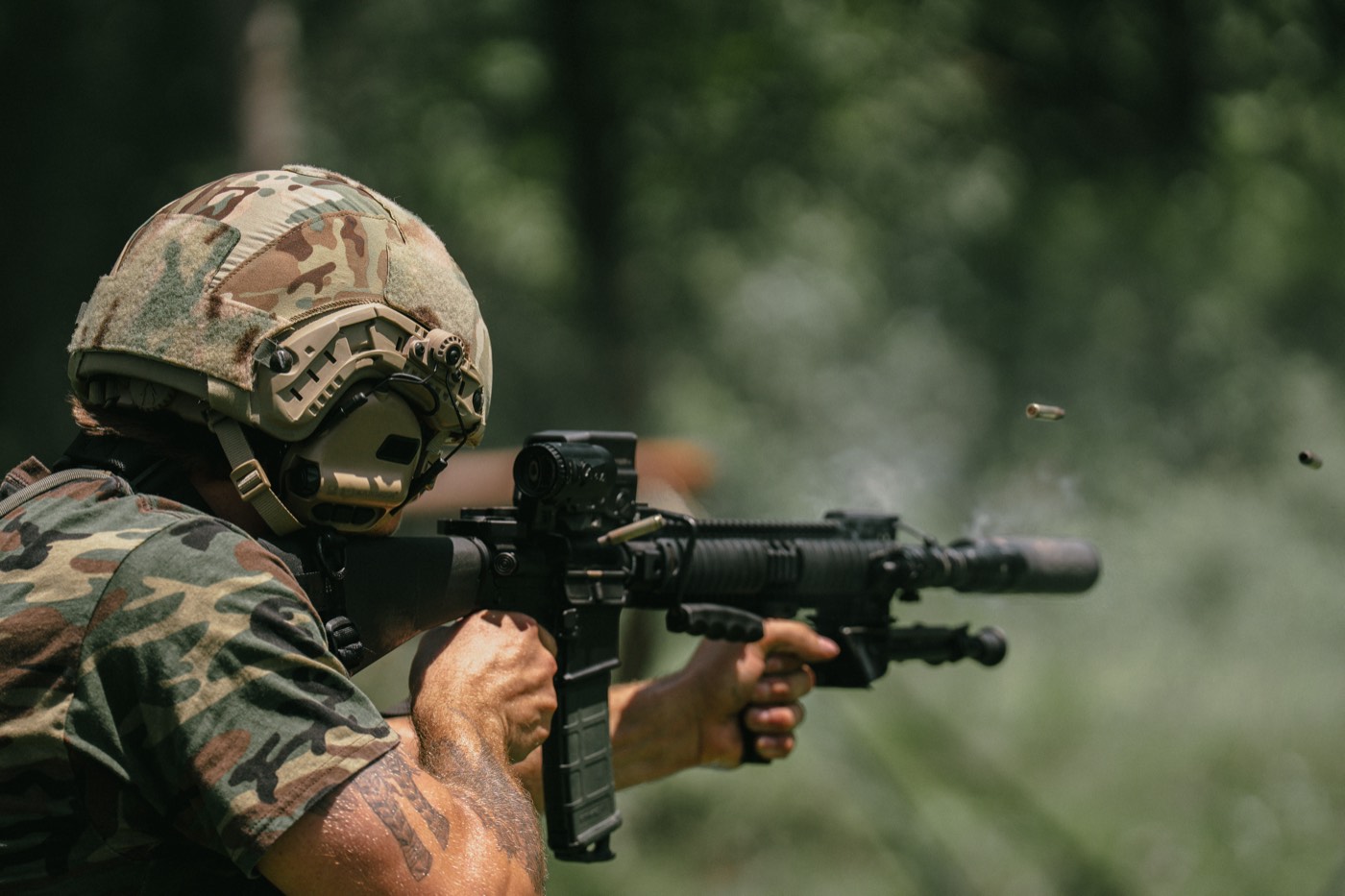 Suppressed AR-15 being fired, spent case in the air