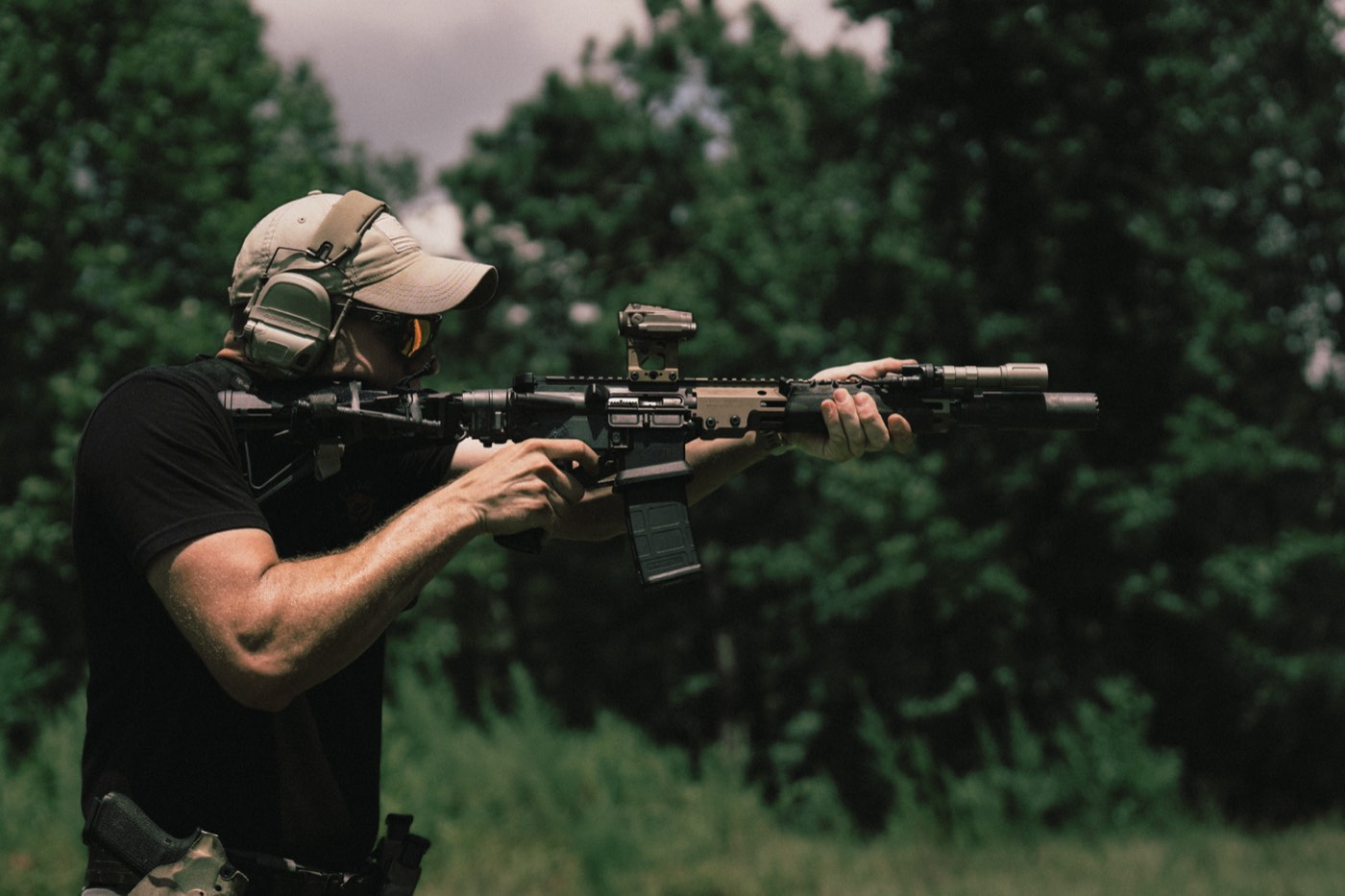 Shooter firing an FDE AR-15 with a weapon light