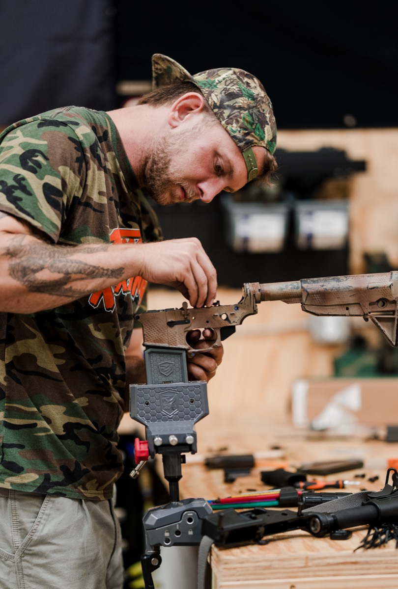 Gunsmith fitting a barrel on an AR-15 clamped in the bench vise