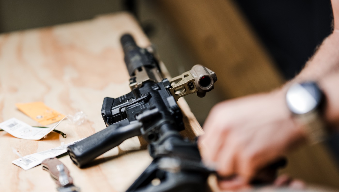 Rifle laid across the workbench alongside gunsmithing tools