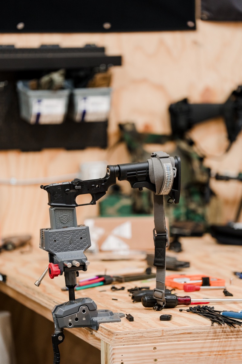 AR-15 lower receiver held in a bench vise with tools laid out