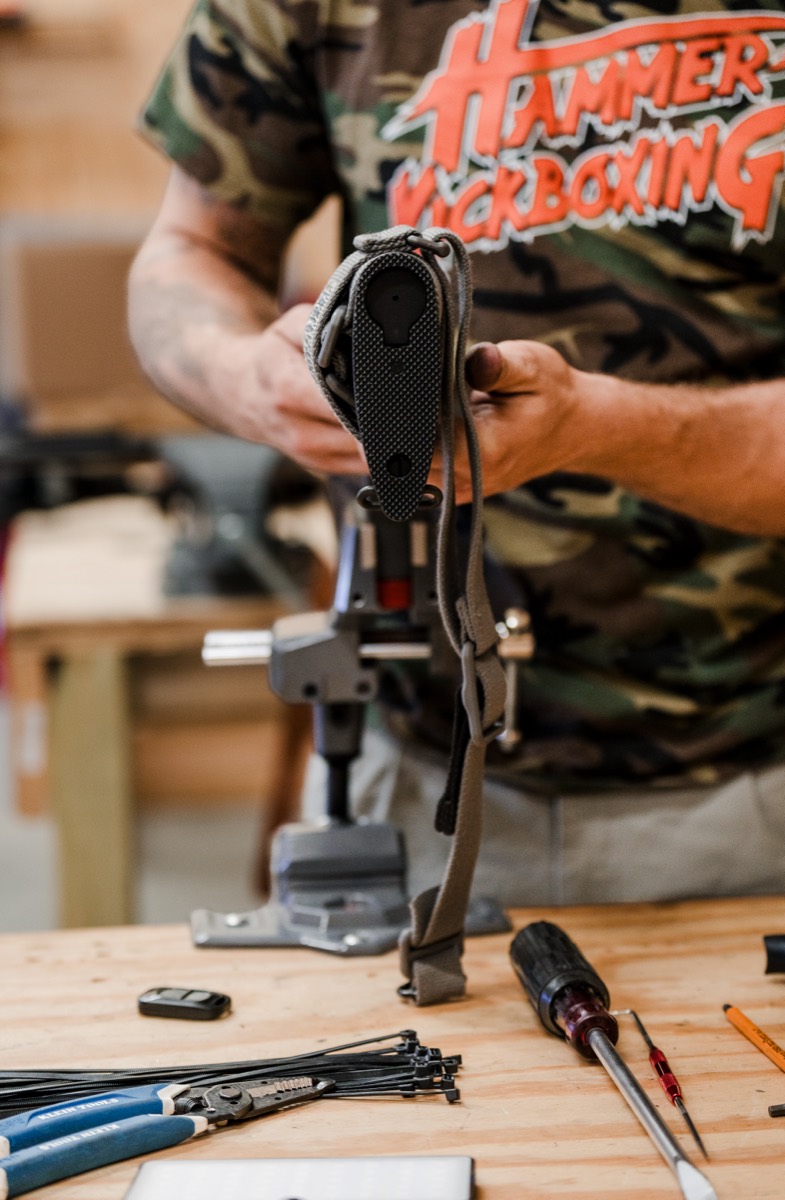 Gunsmith working on an AR lower receiver clamped in a bench vise
